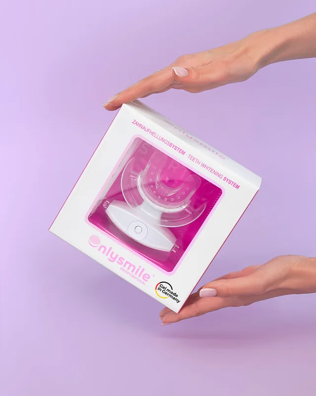 Förpackningen till OnlySmile blekningsset i ett par händer